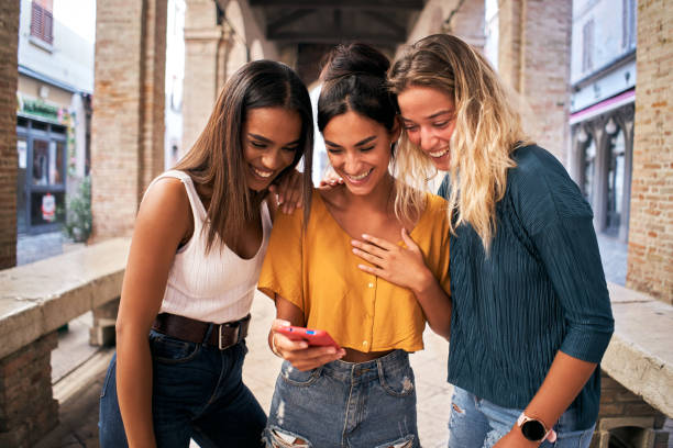 Groupe de sugar babys riant en regardant un téléphone portable